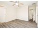 Spacious bedroom with wood-look floors and a ceiling fan, and two doors leading to other rooms at 5022 Chipotle Ln, Wesley Chapel, FL 33544
