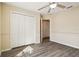 Neutral bedroom features wood-look floors, closet doors, ceiling fan, with doorway access at 5022 Chipotle Ln, Wesley Chapel, FL 33544