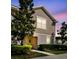 Charming townhome featuring neutral siding, manicured lawn, and welcoming entrance, bathed in a pleasant evening light at 5022 Chipotle Ln, Wesley Chapel, FL 33544