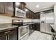 Kitchen featuring dark wood cabinetry, granite countertops, and stainless steel appliances at 5022 Chipotle Ln, Wesley Chapel, FL 33544