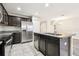Kitchen island featuring dark wood cabinetry, granite countertops, a stainless steel refrigerator, and a sink at 5022 Chipotle Ln, Wesley Chapel, FL 33544
