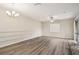 Spacious living room with wood-look floors, a ceiling fan, and stylish light fixture at 5022 Chipotle Ln, Wesley Chapel, FL 33544