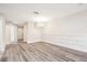 Large living room area with wood-look floors, a modern chandelier, and neutral paint at 5022 Chipotle Ln, Wesley Chapel, FL 33544