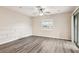 Open living area featuring wood-look floors, ceiling fan and a sliding glass door at 5022 Chipotle Ln, Wesley Chapel, FL 33544