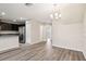 Open-concept living space featuring wood-look floors flowing into the kitchen at 5022 Chipotle Ln, Wesley Chapel, FL 33544