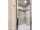 Tiled walk-in shower features a glass door, overhead lighting, and decorative accents at 5022 Chipotle Ln, Wesley Chapel, FL 33544