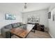 Bedroom featuring a comfortable gray couch, entertainment unit, wood-look floors and bright natural light at 515 Leffingwell Ave # 211, Ellenton, FL 34222