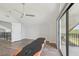 Spacious bedroom with wood floors, ceiling fan, balcony access, and bright natural light at 515 Leffingwell Ave # 211, Ellenton, FL 34222
