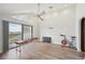 Open bonus room featuring wood floors, balcony access, exercise bike, and bright natural light at 515 Leffingwell Ave # 211, Ellenton, FL 34222