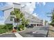 Coastal condo building featuring multi-story balconies, palm trees, and ample parking in a sunny setting at 515 Leffingwell Ave # 211, Ellenton, FL 34222