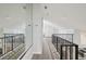 Upstairs hallway featuring wood-look floors, white walls, high ceilings, and black iron railing at 515 Leffingwell Ave # 211, Ellenton, FL 34222