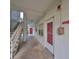 Exterior walkway leading to entrance with stairs and red door, next to the stairs at 5155 9Th N Ave # 102, St Petersburg, FL 33710