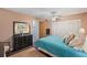 Inviting bedroom features a comfortable turquoise bed, ceiling fan, and access to a bathroom and closets at 5246 81 N St # 24, St Petersburg, FL 33709