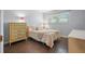 Cozy bedroom with wood floors, a full bed, a large window, and dresser at 5246 81 N St # 24, St Petersburg, FL 33709