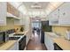 Kitchen with white cabinets, stainless steel appliances, and a view of the living room at 5246 81 N St # 24, St Petersburg, FL 33709