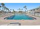 Enjoy a community pool surrounded by lounge chairs, palm trees, and building at 5246 81 N St # 24, St Petersburg, FL 33709