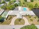 Aerial view of a complex with a pool, tennis courts, ample parking, and a central location at 5428 Larchmont N Ct # 5428, Pinellas Park, FL 33782