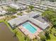 Aerial view of a complex with a pool, tennis courts, ample parking, and a central location at 5428 Larchmont N Ct # 5428, Pinellas Park, FL 33782