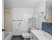 Bright bathroom featuring blue tiled accents, a vanity, and a toilet with shelving at 5428 Larchmont N Ct # 5428, Pinellas Park, FL 33782
