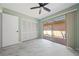 This bedroom features an exterior view to a patio and a ceiling fan at 5428 Larchmont N Ct # 5428, Pinellas Park, FL 33782