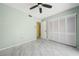 This bedroom leads to the closet, bathroom, and features a ceiling fan at 5428 Larchmont N Ct # 5428, Pinellas Park, FL 33782