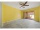 This bedroom features an exterior view to the outside patio and a ceiling fan at 5428 Larchmont N Ct # 5428, Pinellas Park, FL 33782