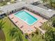 Aerial view of a community pool surrounded by seating and lush landscaping at 5428 Larchmont N Ct # 5428, Pinellas Park, FL 33782