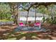 Inviting backyard seating area with stylish chairs under mature trees offering shade and relaxation at 559 Scotland St, Dunedin, FL 34698
