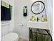 Bathroom featuring modern fixtures, a floating sink, a round mirror, and decorative towels and plants at 559 Scotland St, Dunedin, FL 34698