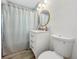 Stylish bathroom with patterned shower curtain, decorative wallpaper, and updated vanity at 559 Scotland St, Dunedin, FL 34698