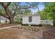 Cozy home with quaint landscaping including stepping stones, planters, and large shade tree at 559 Scotland St, Dunedin, FL 34698