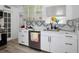 Modern kitchen featuring white cabinets, stainless steel appliances, and a unique backsplash at 559 Scotland St, Dunedin, FL 34698