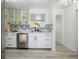 Bright kitchen with white cabinetry, stainless steel appliances, and geometric backsplash, seamlessly blending style and functionality at 559 Scotland St, Dunedin, FL 34698