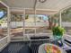 Screened-in porch with outdoor seating, black and white rug, and a view of the backyard at 559 Scotland St, Dunedin, FL 34698