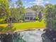 Aerial view of a backyard with a serene pond, lush trees, and a well-maintained lawn at 5619 Tranquil Pond Pl, Riverview, FL 33578