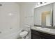 Clean bathroom with tiled shower-tub, toilet, and single sink vanity with a modern mirror at 5619 Tranquil Pond Pl, Riverview, FL 33578