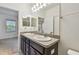 Double sink vanity with a large mirror in the primary bath, with attached bedroom at 5619 Tranquil Pond Pl, Riverview, FL 33578