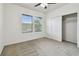 Bedroom with neutral carpet, ceiling fan, and windows overlooking trees at 5619 Tranquil Pond Pl, Riverview, FL 33578