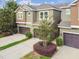 Aerial view of a townhome with a driveway and lush landscaping at 5619 Tranquil Pond Pl, Riverview, FL 33578