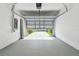 Clean, empty garage with epoxy floor and a garage door that opens to the driveway at 5619 Tranquil Pond Pl, Riverview, FL 33578