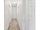 Bright hallway featuring carpet flooring and several white doors at 5619 Tranquil Pond Pl, Riverview, FL 33578