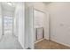 Bright upstairs hallway featuring laundry closet and a view into another bedroom at 5619 Tranquil Pond Pl, Riverview, FL 33578