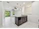 Open-concept kitchen boasts an island with sink and dishwasher, plus views of the living area and pond at 5619 Tranquil Pond Pl, Riverview, FL 33578
