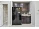 Kitchen features dark cabinets, a black refrigerator, stone countertops, and a stylish backsplash at 5619 Tranquil Pond Pl, Riverview, FL 33578