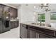 The open-concept kitchen with island flows into the living area and features a modern black appliance package at 5619 Tranquil Pond Pl, Riverview, FL 33578