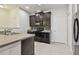 Modern kitchen with dark cabinets, stainless steel appliances, and a tiled backsplash at 5619 Tranquil Pond Pl, Riverview, FL 33578