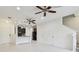 Open-concept living space with tile floors, ceiling fans, and a view into the kitchen at 5619 Tranquil Pond Pl, Riverview, FL 33578