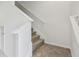 A carpeted staircase with white banister leads to the upper level of the house at 5619 Tranquil Pond Pl, Riverview, FL 33578