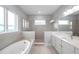 An elegant bathroom features a soaking tub, glass shower, double sinks, and natural light from windows at 6023 Cat Claw Ln, Bradenton, FL 34210