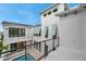 Stunning white modern home with black framed windows and shutters overlooking a pool at 6023 Cat Claw Ln, Bradenton, FL 34210